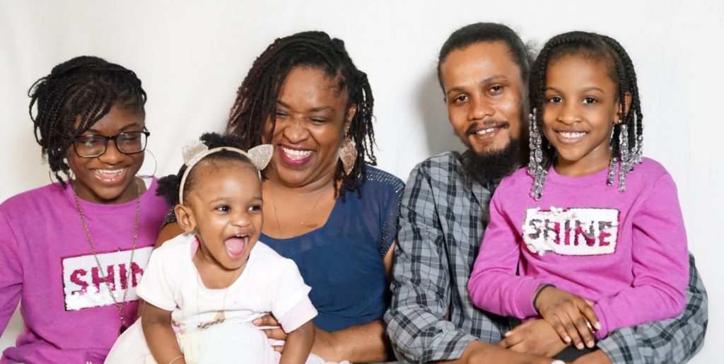 A family is seated together smiling