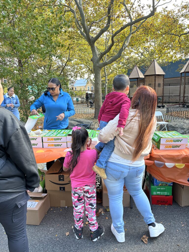 Woman stands with her daughter and son at a table.