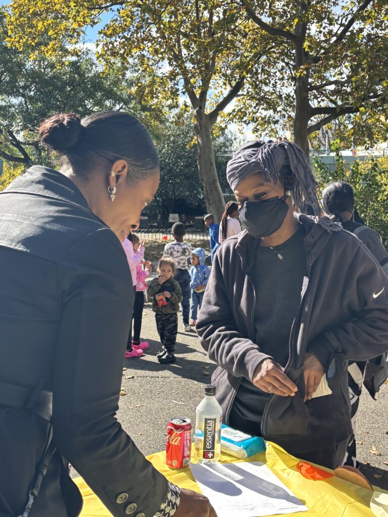 A woman wearing a mask signs in at a registration desk