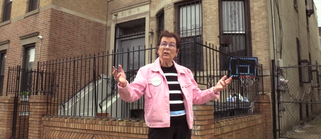 Rita Zimmer, founder of HousingPlus, stands in front of a building where tenants live.