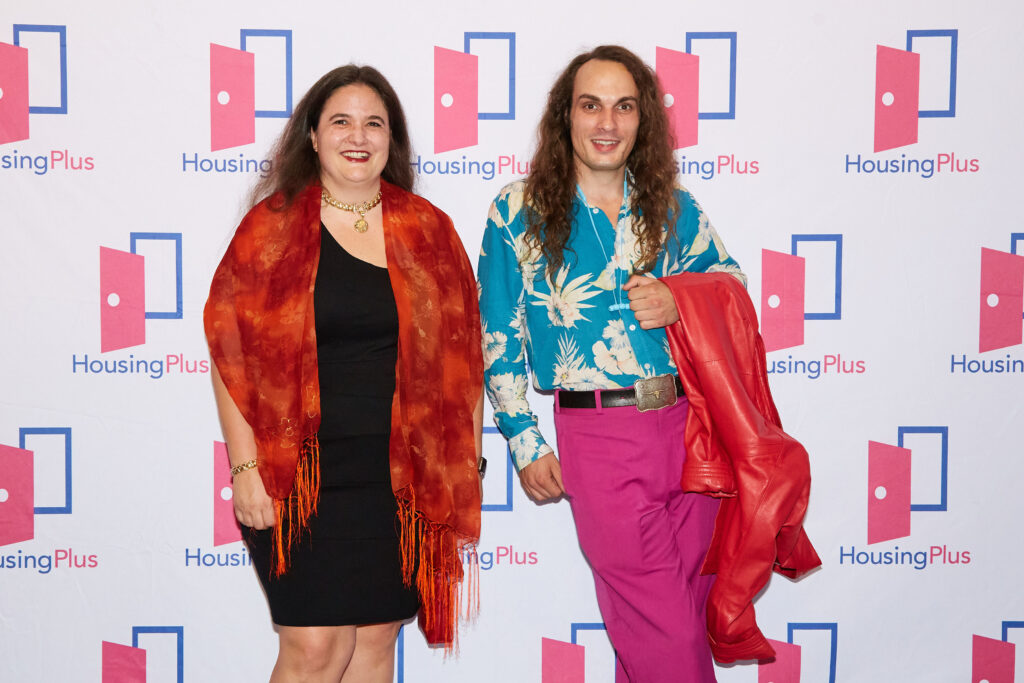 Two people pose in very colorful clothing