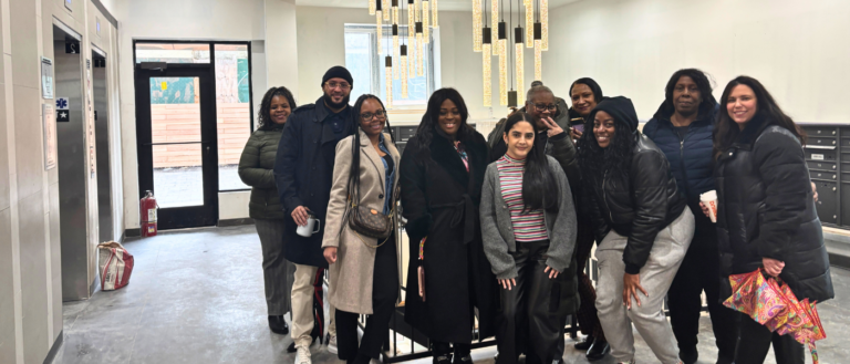 group of individual staff people standing in lobby of building