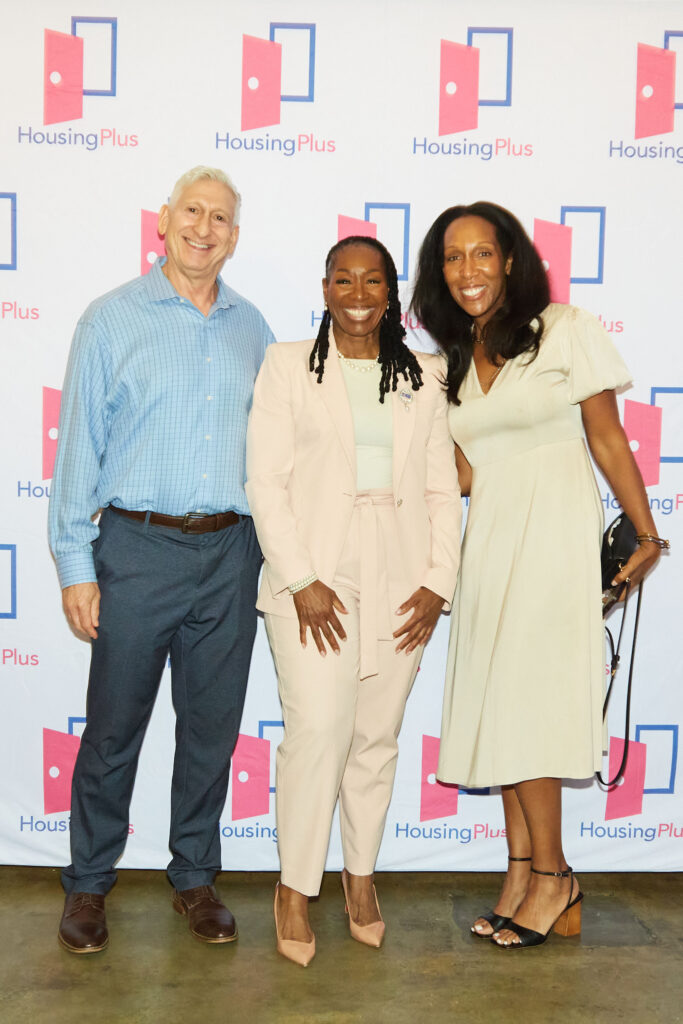 Three people face the camera smiling broadly